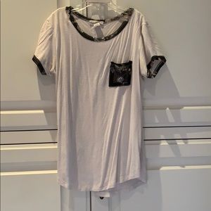 A white shirt with flower detailing on pocket